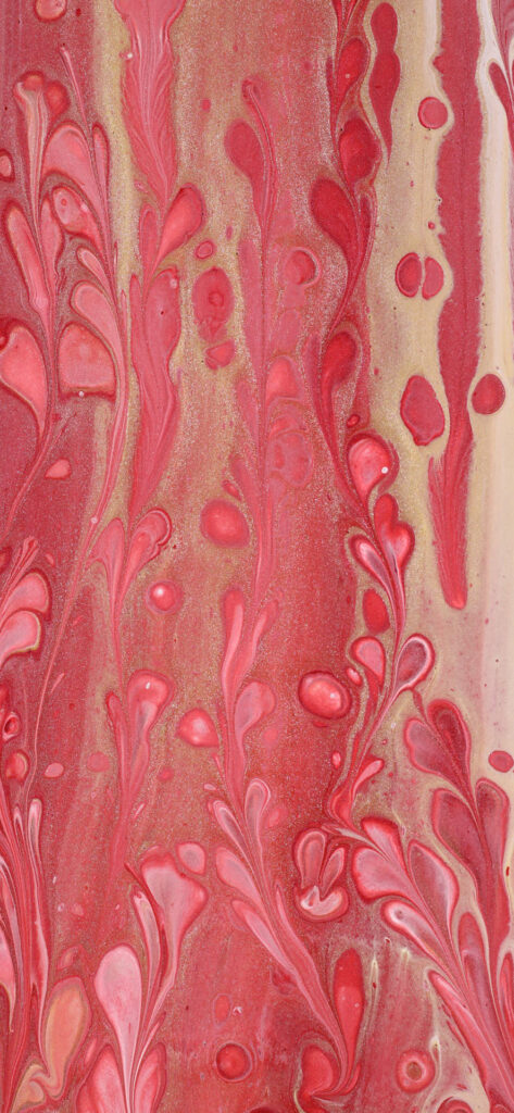 A close-up of a marbled pattern with swirling red, pink, and white colors.
