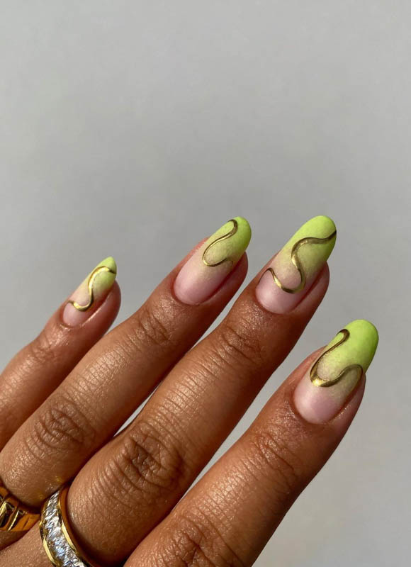 A hand with pale pink and bright green wavy nail art design.
Spring Nail Ideas For 2024.