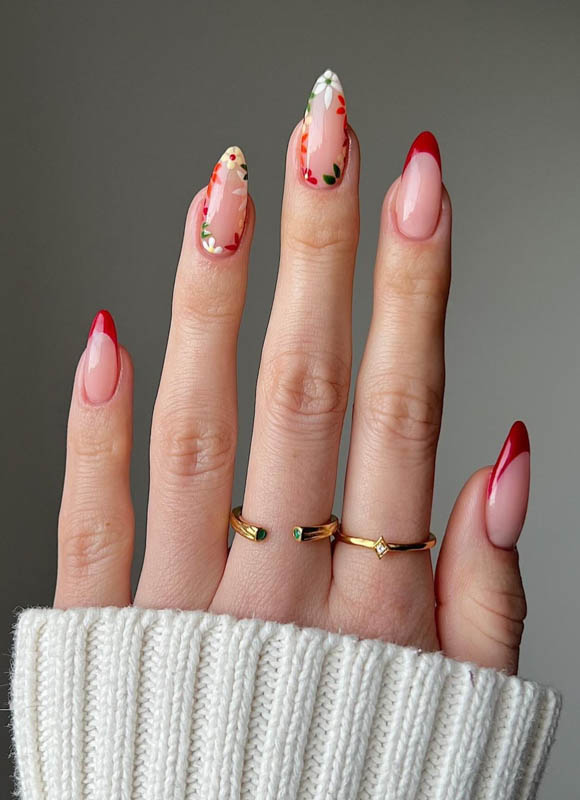 A hand with red French tip, flowers and gold rings on a grey background.
Spring Nail Ideas For 2024.